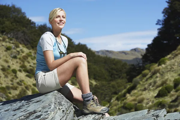 Woman sitting on boulder — Stock Photo, Image