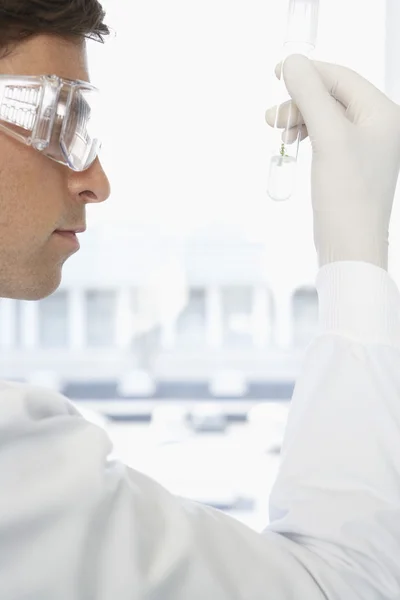 Científico examinando solución en tubo de ensayo — Foto de Stock