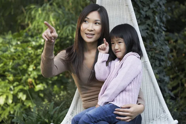 Mamma sitter med dotter i knä — Stockfoto