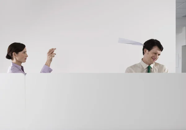 Vrouw het gooien van papier vliegtuig op collega — Stockfoto