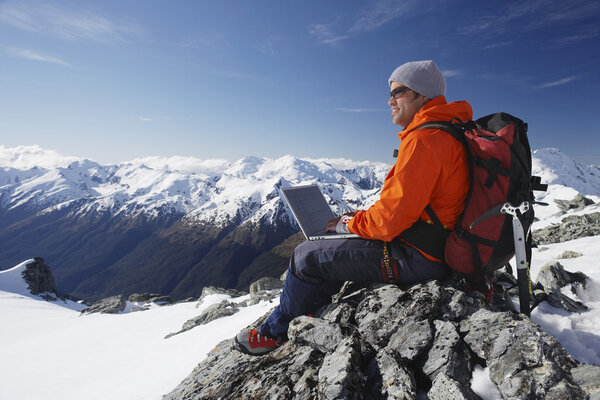 Mountain climber using laptop