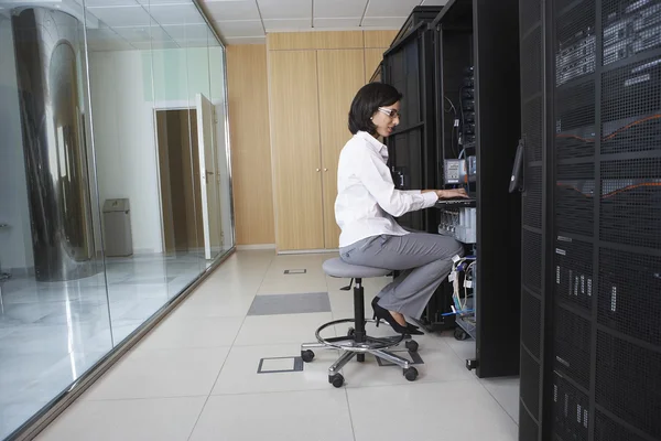 Técnico femenino trabajando en la sala de servidores — Foto de Stock