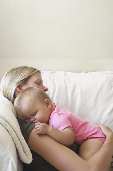 Anne ve kanepede uyuyan bebek — Stok fotoğraf