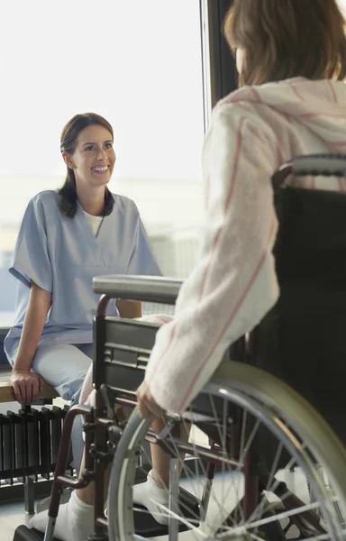 Doente em cadeira de rodas com médico — Fotografia de Stock