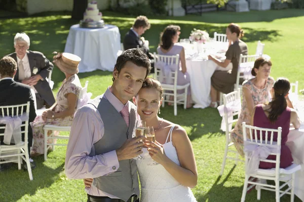Braut und Bräutigam stoßen am Empfang an — Stockfoto