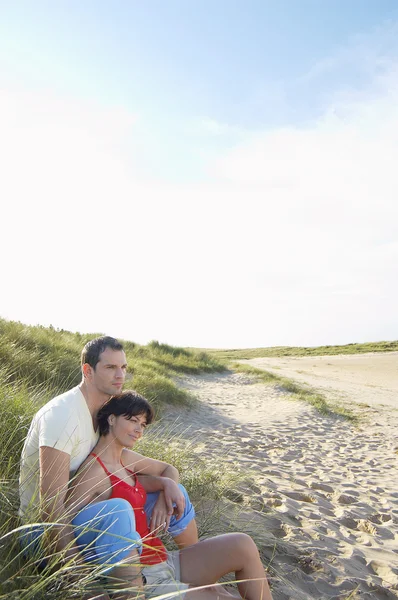 坐在海滩上的情侣 — 图库照片