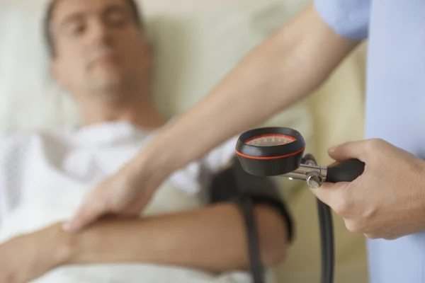 Nurse taking blood pressure and pulse — Stock Photo, Image