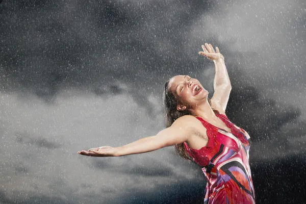 Vrouw armen gestrekt in de regen — Stockfoto