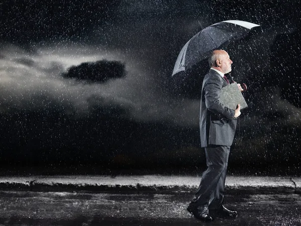 Бизнесмен, гуляющий под дождем — стоковое фото