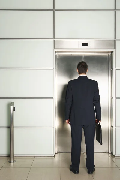 Бизнесмен ждет лифт — стоковое фото