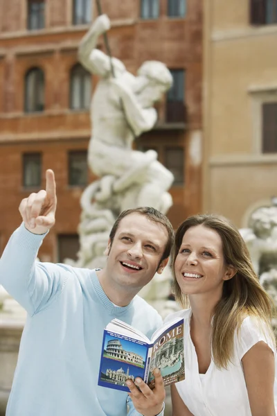 Couple with guidebook — Stock Photo, Image