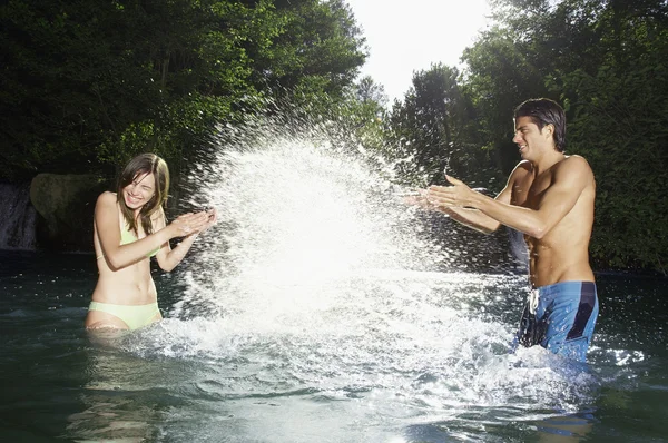 Couple splashing water — Stock Photo, Image