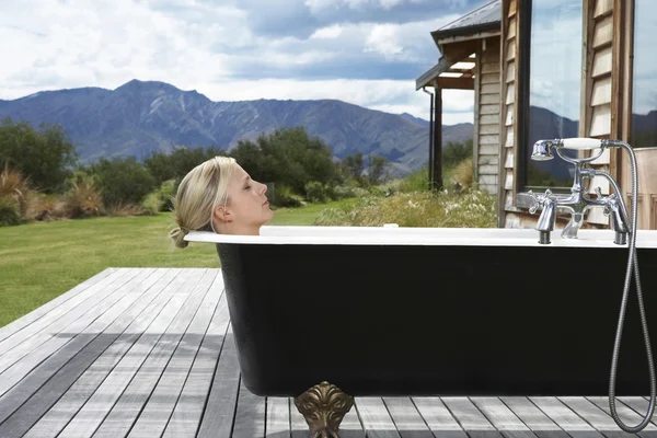 Kobieta biorąc kąpiel na ganku — Zdjęcie stockowe
