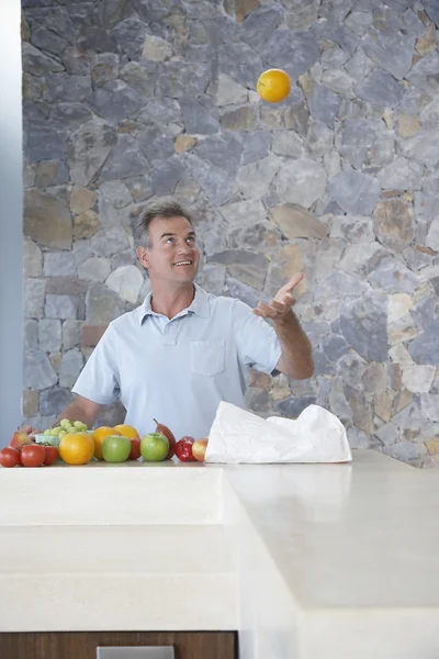 Hombre haciendo malabares con una naranja —  Fotos de Stock