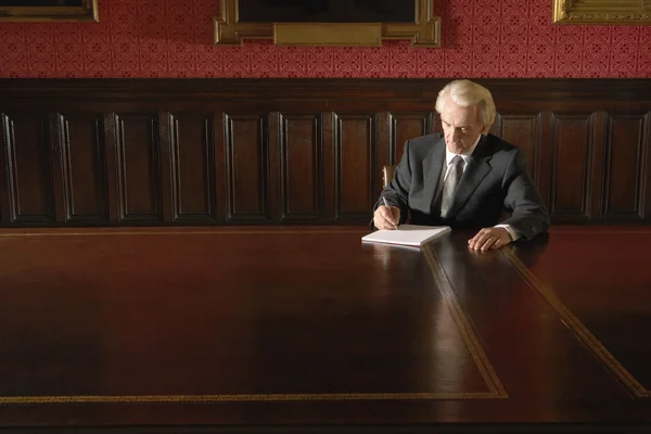 Homme assis dans la salle de conseil d'administration écriture — Photo