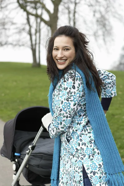 Mother walking with baby carriage — Stock Photo, Image