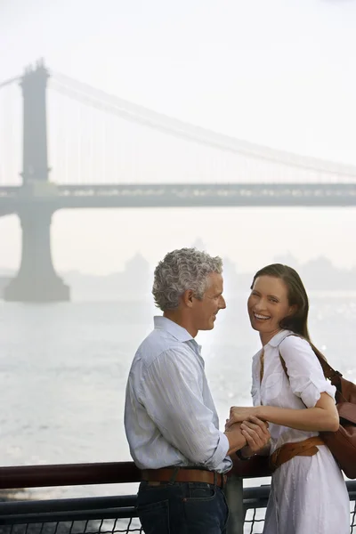 Couple holding hands by river — Stock Photo, Image