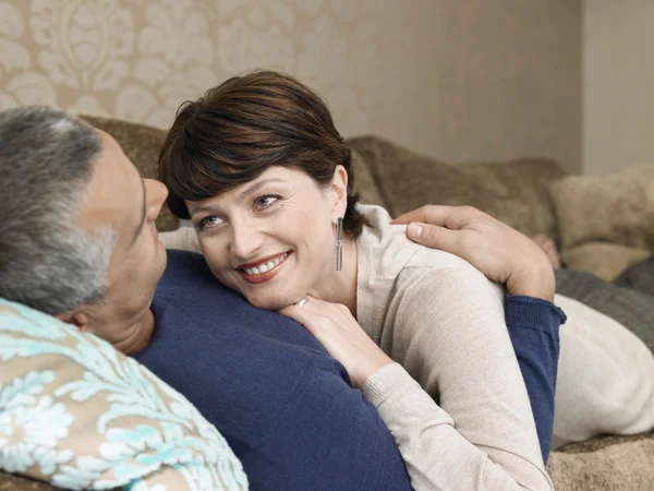 Coppia sorridente che si rilassa sul divano — Foto Stock