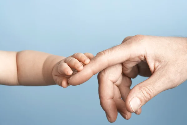 Baby en man handen aan te raken — Stockfoto