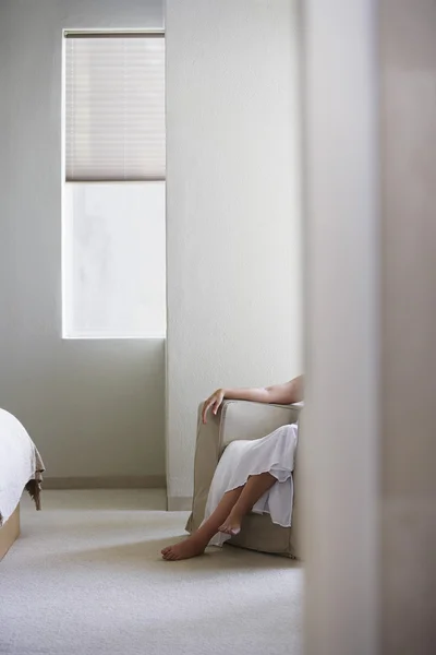 Woman sitting on armchair in bedroom — Stock Photo, Image