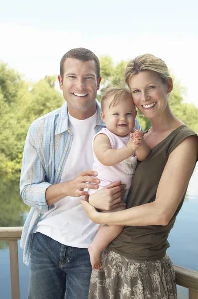 Couple avec enfant debout au bord du lac — Photo