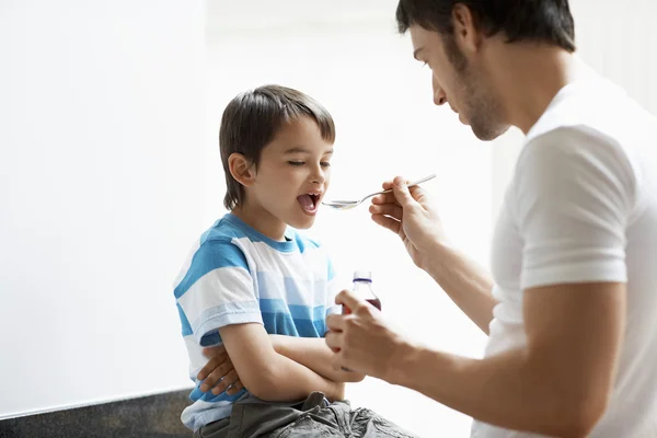 Pai dando filho tosse xarope — Fotografia de Stock