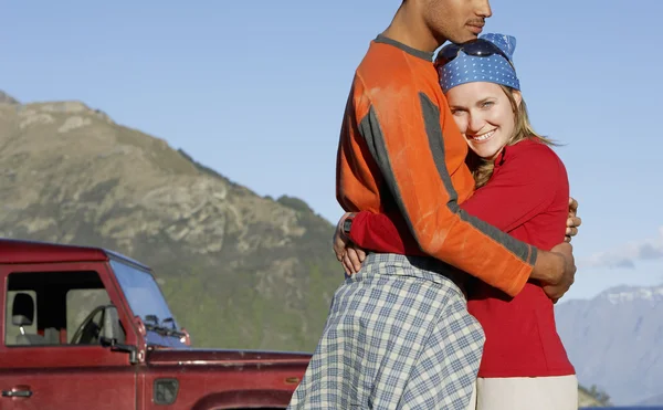 Mujer abrazando hombre cerca de jeep — Foto de Stock