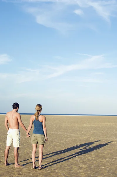 Couple on beach looking to sea — Stock Photo, Image