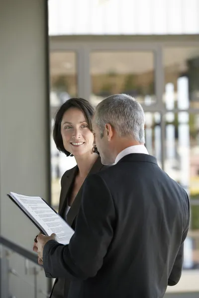 Businessman talking to businesswoman. — Stock Photo, Image