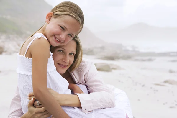 Mother and daughter hugging on beach — Stock Photo, Image