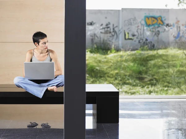 Woman sitting down using laptop — Stock Photo, Image