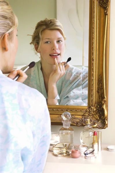 Mujer en albornoz Aplicando maquillaje —  Fotos de Stock