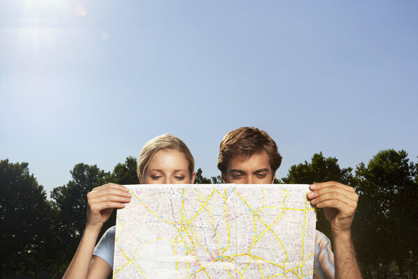 Vacationing couple looking at large map