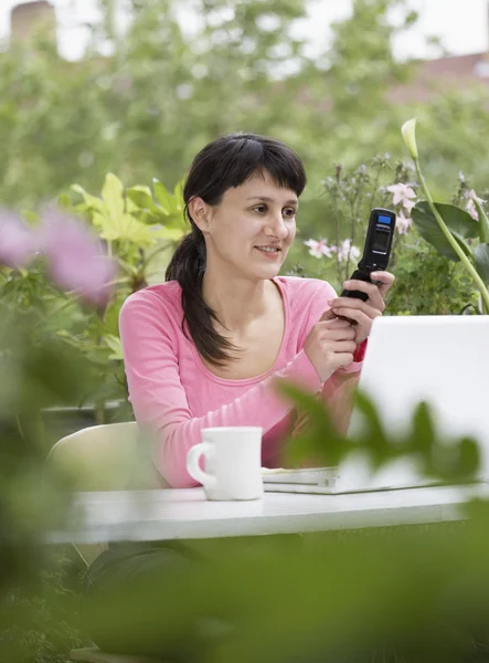 Geschäftsfrau mit Handy und Laptop — Stockfoto