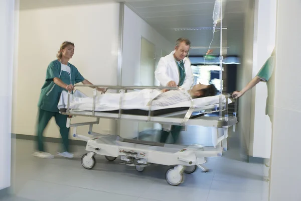 Médicos em movimento paciente na maca — Fotografia de Stock