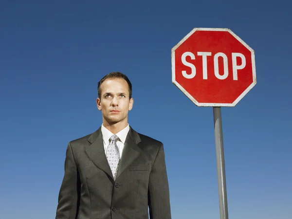 Man standing next to sign — Stock Photo, Image