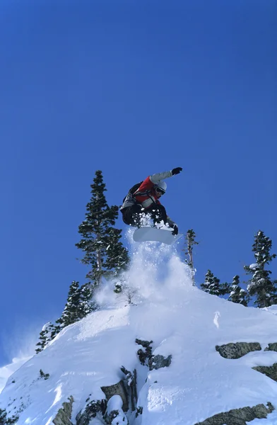 Snowboarder jumping from mountain ledge — Stock Photo, Image
