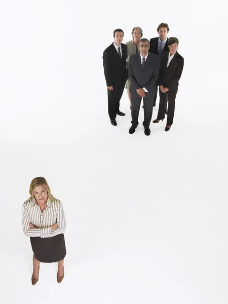 Businesswoman standing apart from group — Stockfoto