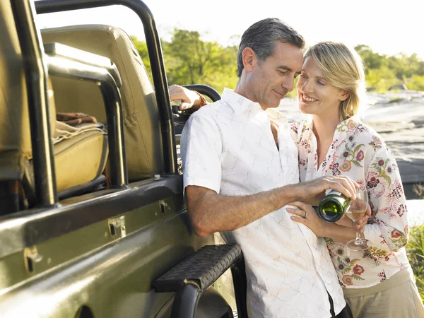 Couple standing by jeep — Stock Photo, Image