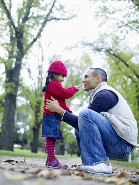 Girl playing with father in park — Stock Photo, Image