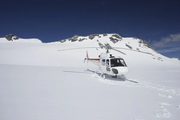 Helicóptero na montanha nevada — Fotografia de Stock