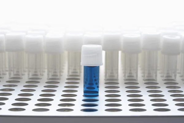 Blue test tube with empty test tubes — Stock Photo, Image