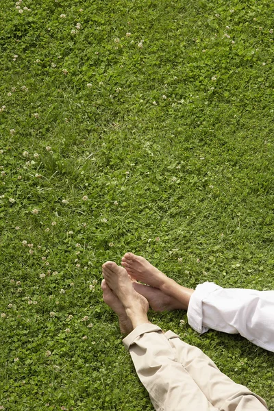 Paar liegt im Gras — Stockfoto