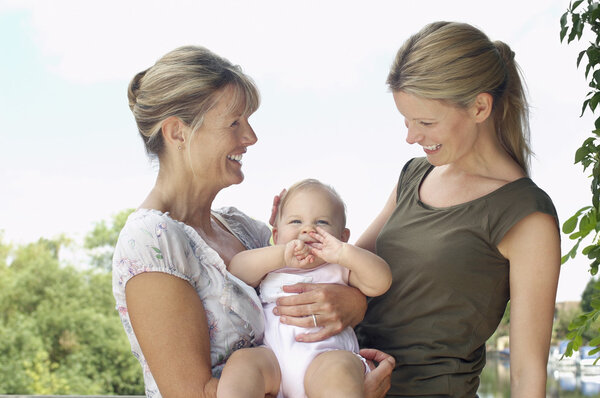 Grandmother mother and daughter by lake