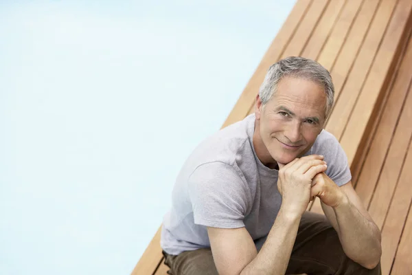 Man sitting by pool — Stock Photo, Image