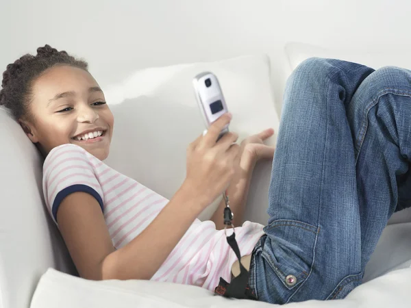 Smiling Girl lying on sofa — Stock Photo, Image