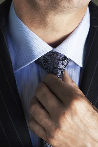 Businessman adjusting tie — Stock Photo, Image