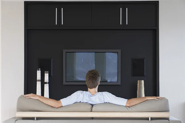 Man in front of flat screen television — Stock Photo, Image