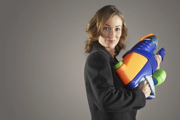 Glimlachende zakenvrouw bedrijf water gun automatische waterpistool — Stockfoto