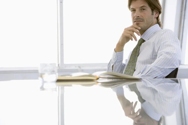 Geschäftsmann sitzt am Konferenztisch — Stockfoto